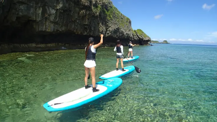 アンダゴのSUPツアーで、親子がボードの上から透明度の高い海を楽しんでいる様子