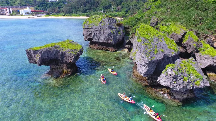 アルガイドのカヤックツアーで、家族が青い海の上を進みながら青の洞窟を目指している様子