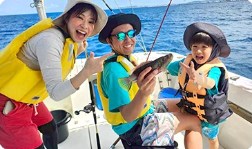 釣った魚を囲む家族の笑顔