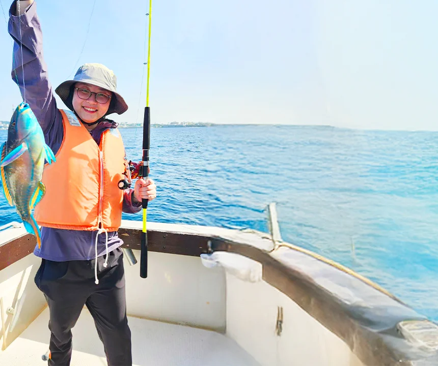 船の上で魚を掲げる子ども