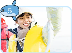 魚を掲げて笑顔を見せる参加者