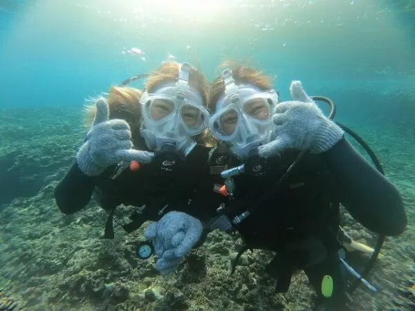 ナギのフルフェイスダイビングで、フルフェイスマスクをつけて青い海の中を泳ぐダイバー