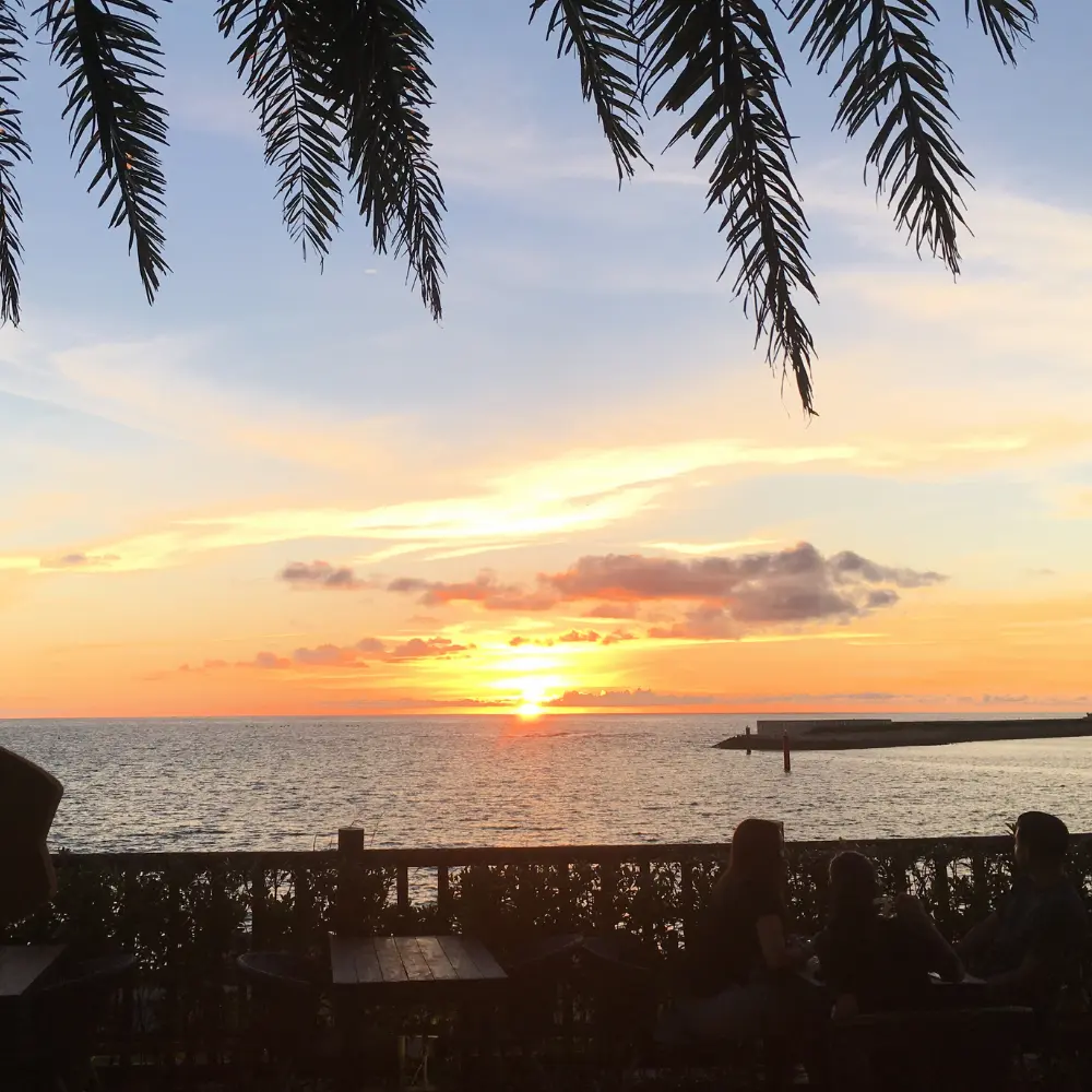 サンセットビーチの夕陽。海辺に多くの人が集まる人気の夕陽スポット。