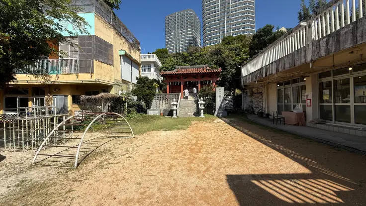 安里八幡宮の本殿と、隣接する保育園の庭が見える境内の風景。街なかでも落ち着いた空気が流れている。