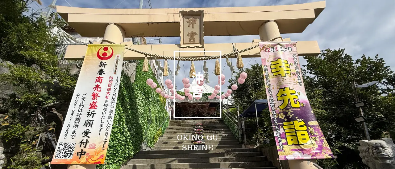 沖宮の鳥居。緑に包まれた参道の入口に、落ち着いた色合いの鳥居が立つ風景。