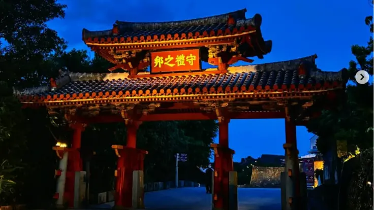 ライトアップされた首里城の守礼門。夜の静けさの中に朱色が浮かぶ幻想的な風景。