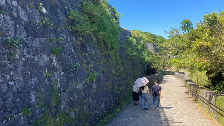 首里城公園の石垣沿いを歩く観光客
