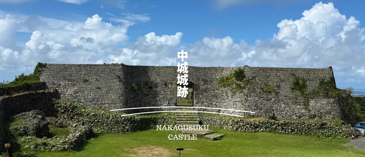 中城城跡の石積みの城壁と、中城湾を見渡せる高台の遊歩道の風景