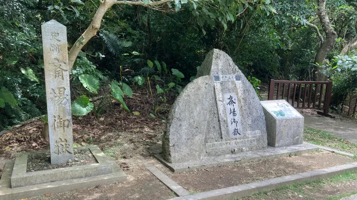 斎場御嶽の入口付近にある石碑と案内図。歴史を感じる石の案内が置かれている風景