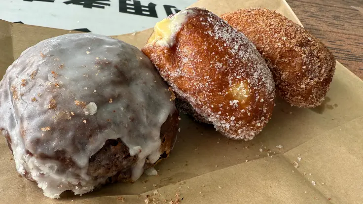 ハワイ名物マラサダドーナツとドリンクのセット。外はふんわり、中はもっちりとした食感で、見た目もかわいい。