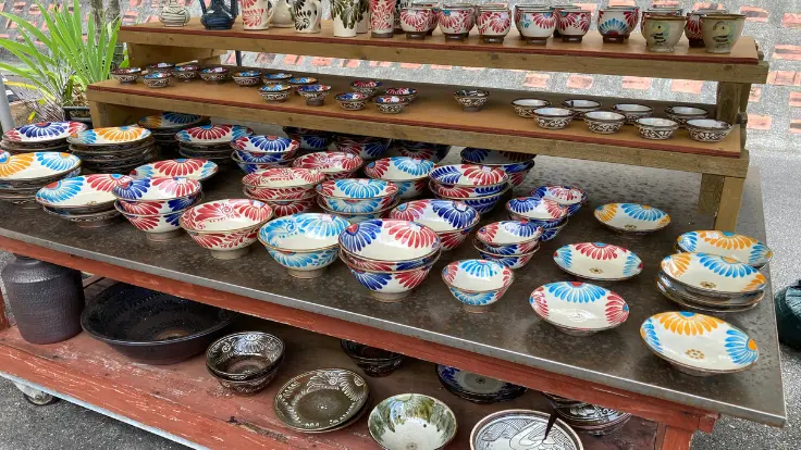 カラフルなやちむんの作品がテーブルに並んでいる様子