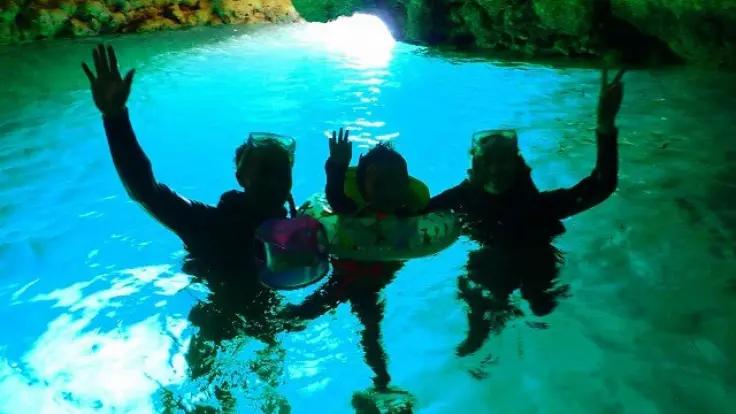 青の洞窟の中で青い光に感動するファミリーの様子