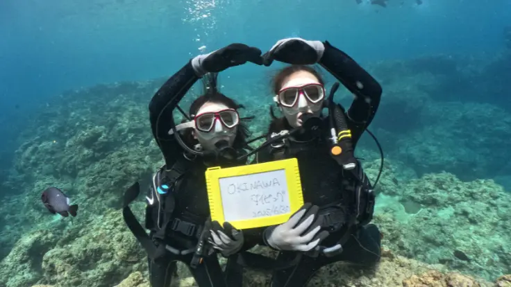 青の洞窟でダイビングを楽しむ参加者。ウェットスーツと器材を身につけている様子