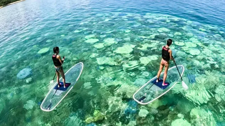 沖縄の海でクリアサップを楽しむ様子。サンゴや海の色まで感じられる、沖縄らしい写真が残せる体験イメージ