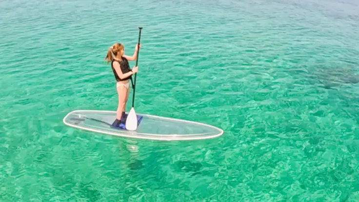 沖縄の海でクリアサップに乗る様子。透明なボードで海の景色を楽しめるアクティビティイメージ