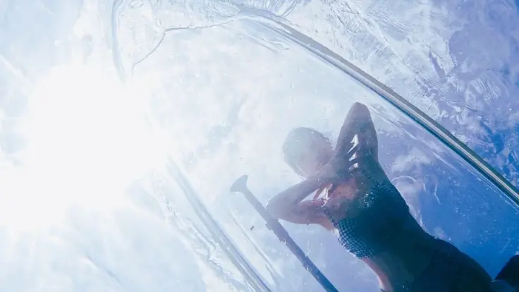 普通のSUPとの違いがわかるクリアサップ体験の様子。透明なボードごしに海が見えるイメージ