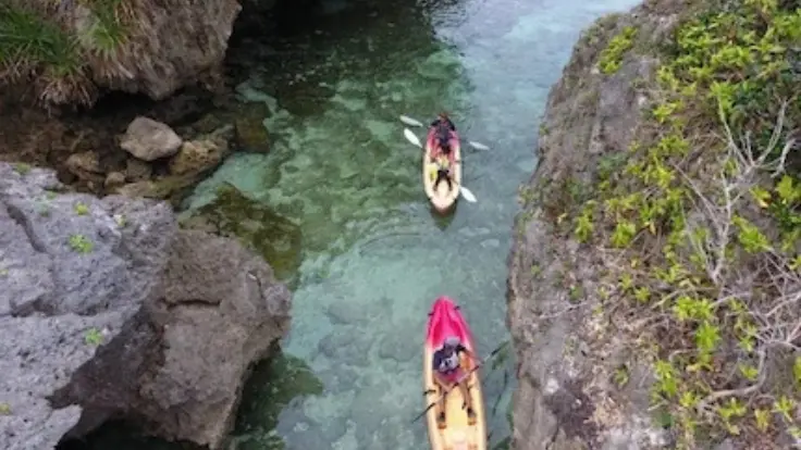 雨の中でカヤック体験をしているイメージ。水面に雨粒が落ち、自然の音が感じられる雰囲気