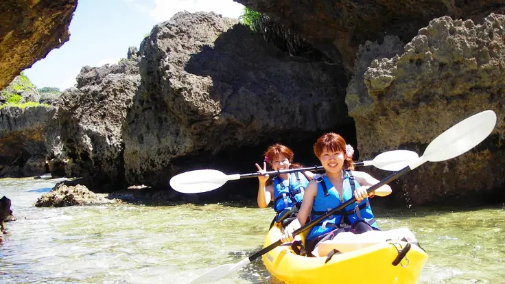 沖縄の水辺でカヤックを体験している様子。水面の照り返しがあり日差し対策が必要なイメージ