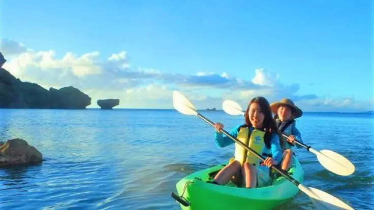 沖縄・恩納村の透明度の高い海でクリアカヤックを体験している様子。カヤックの底が透明で海の中が見えるイメージ