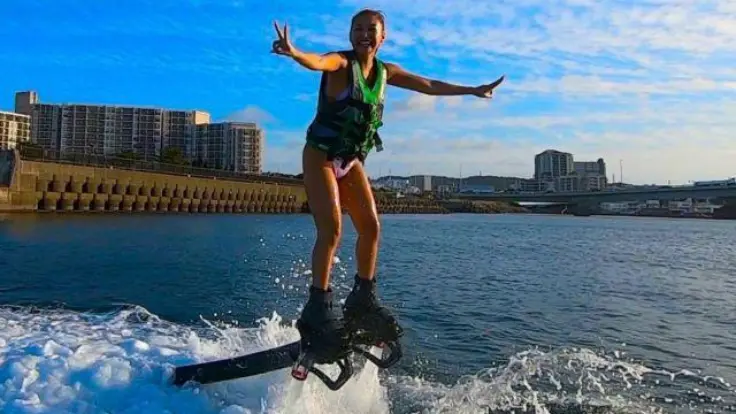 沖縄の海でフライボードを楽しんでいる様子。水の力で海の上に浮かびながら体験するマリンスポーツイメージ。