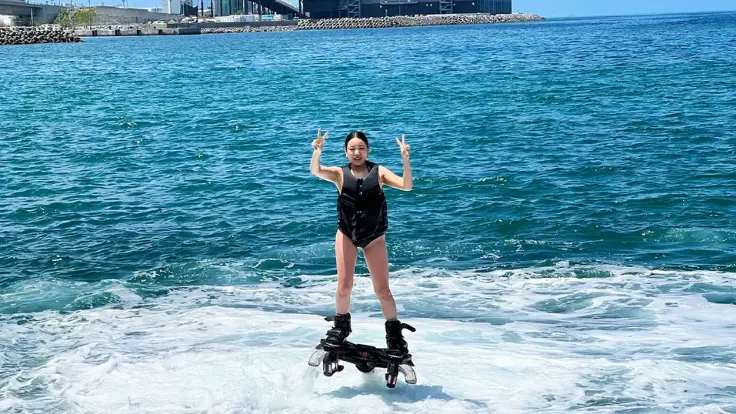 沖縄の海でフライボードを楽しんでいる様子。水の力で海の上に浮かび上がる、特別感のあるマリンスポーツ体験イメージ。