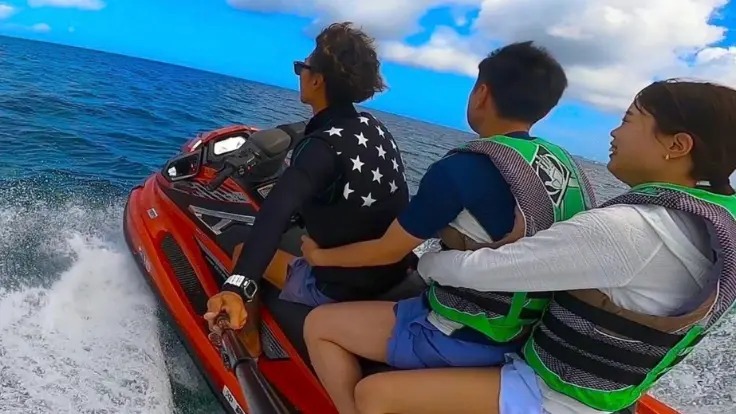 沖縄の海でジェットスキーを楽しんでいる様子。海の上を爽快に走るマリンスポーツ体験イメージ。