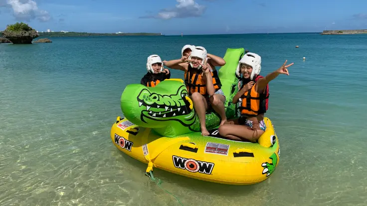 沖縄の海でチューブ系マリンスポーツを楽しんでいる様子。乗り物の形によって動きやスリルが変わる体験イメージ。