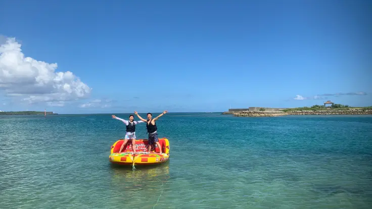 沖縄の海でチューブ系マリンスポーツを楽しんでいる様子。短時間でも気軽に参加しやすい体験イメージ。