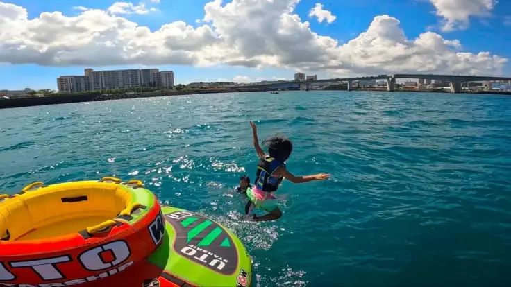 沖縄の海で思いきり海あそびを楽しむ様子。子どもも笑顔になれる思い出の体験