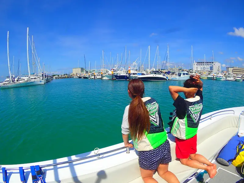 ボートからの景色とパラセーリングを同時に楽しむ雰囲気をイメージできる写真