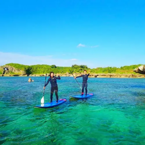アースシップ沖縄のSUPツアー。家族や友達と沖縄の海を楽しむ自然体験の様子。