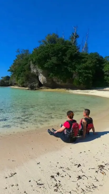 アースシップ沖縄のビーチ滞在。砂浜でのんびり過ごしながら、恩納村の海と島時間を楽しむ様子。