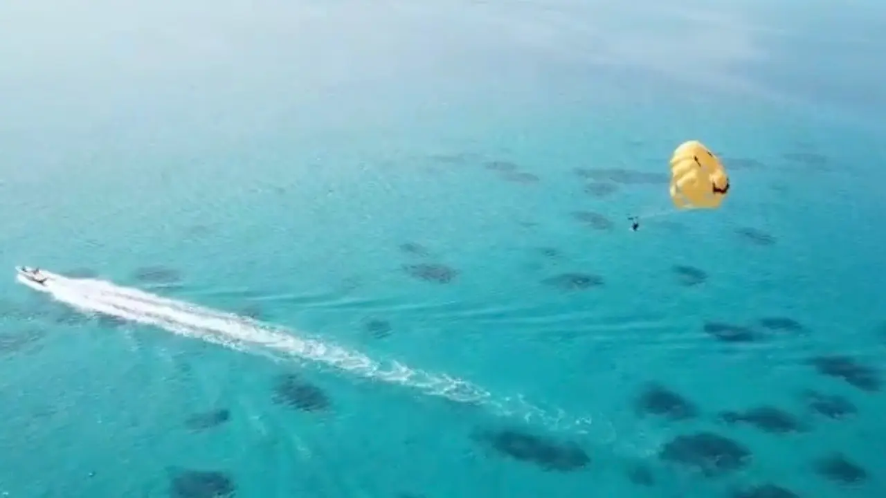 綺麗な海とパラセール体験の全体が伝わるドローン撮影画像