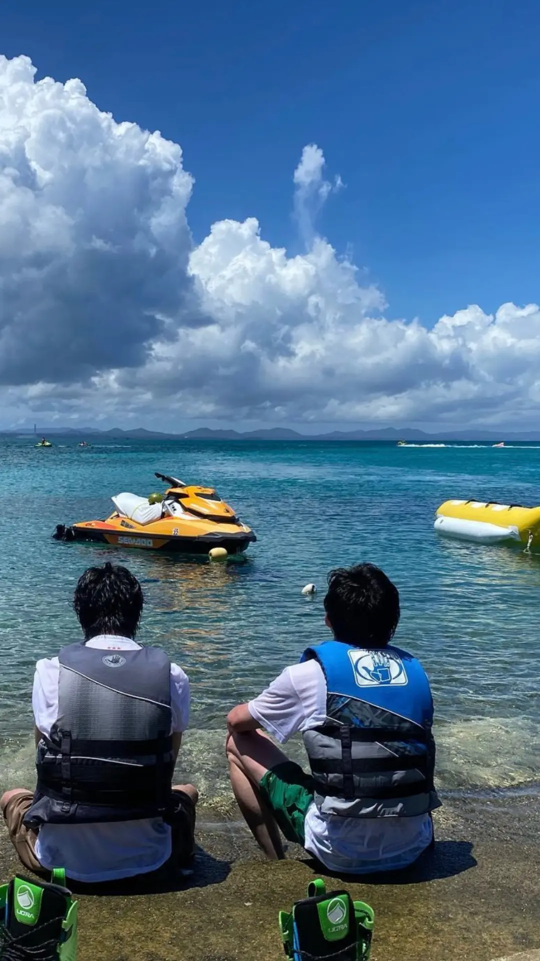 沖縄の海と空を背景にしたパラセーリング体験の様子