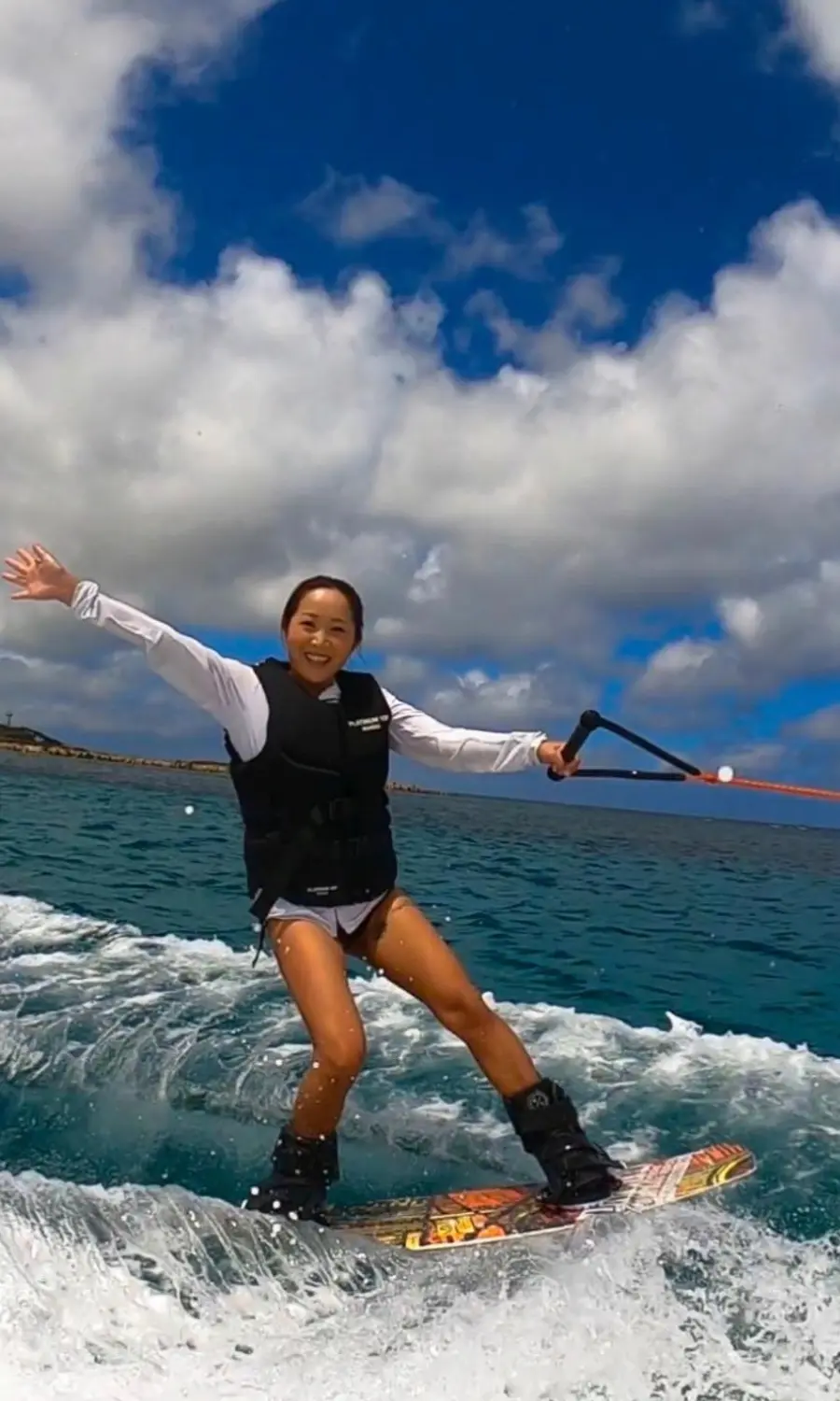 沖縄の海でウェイクボードを楽しむ女性