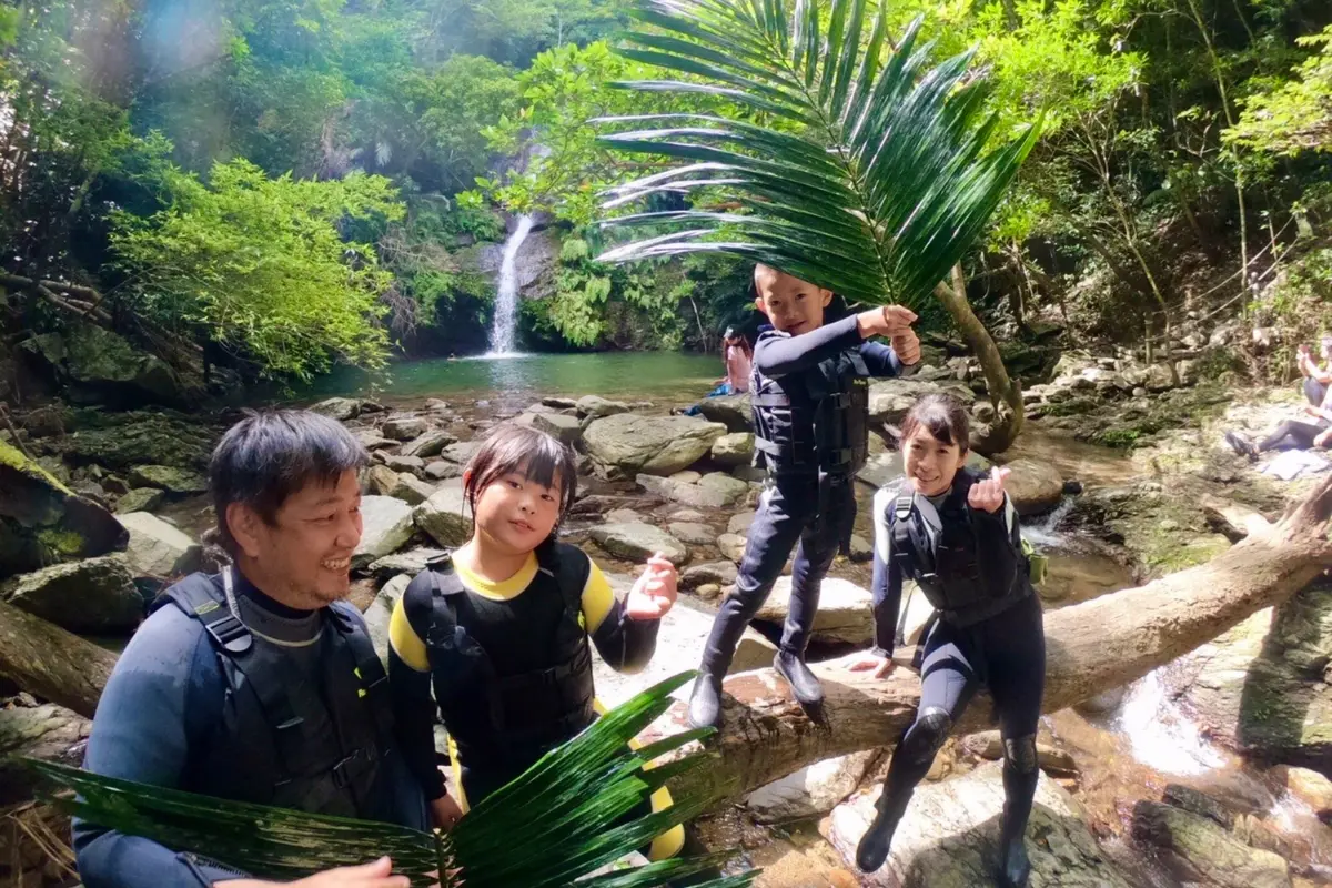 わくわく屋 沖縄のファミリーリバートレッキング。やんばるの川辺で家族で自然体験を楽しむ様子。