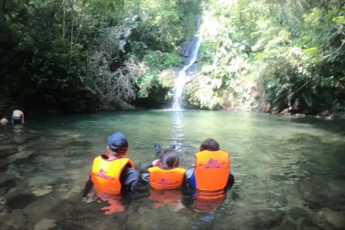 わくわく屋 沖縄のファミリーリバートレッキングイメージ2。やんばるの川辺で遊ぶ家族の様子。