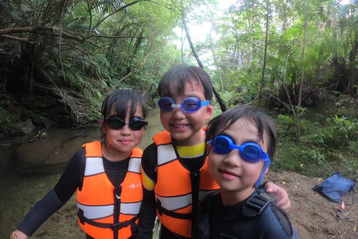 わくわく屋 沖縄のファミリーリバートレッキングイメージ5。川辺で自然観察を楽しむシーン。