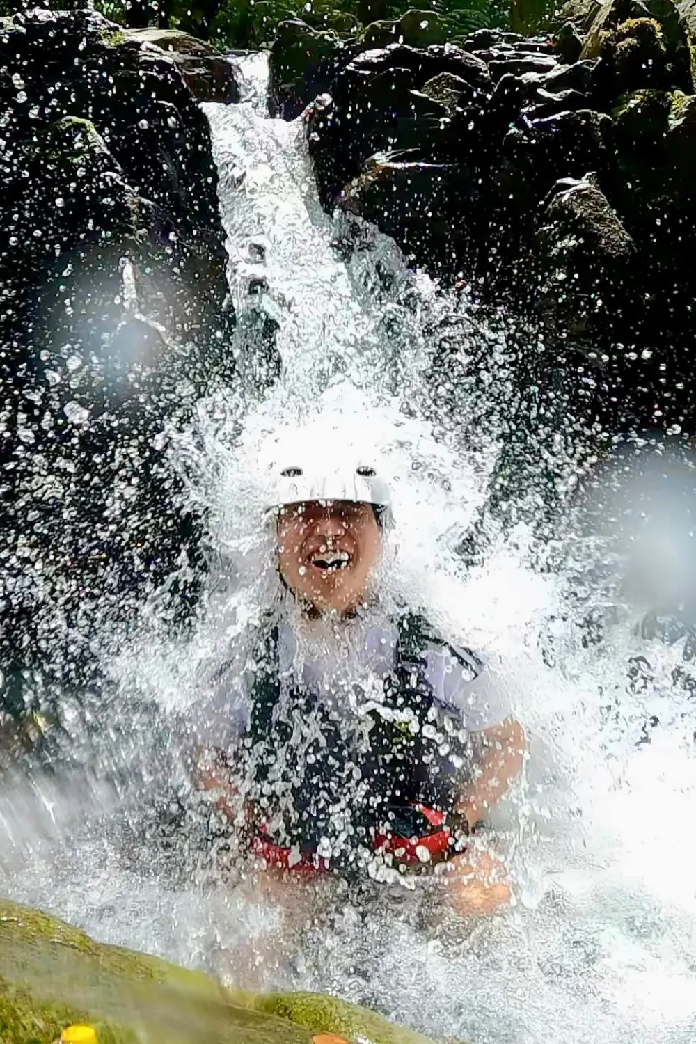 わくわく屋 沖縄の滝あそびイメージ。頭から滝を浴びながら自然を楽しむ様子。