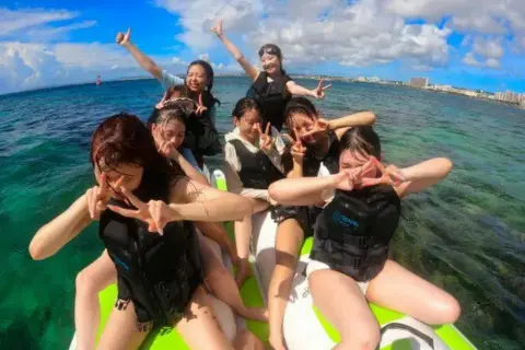 沖縄で団体グループがバナナボートを楽しんでいる