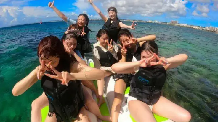 大人数のグループでバナナボートにのってワイワイ楽しんでいるイメージ写真（マリンアクティビティ）